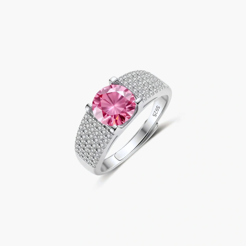 Adjustable sterling silver ring with round pink moissanite center stone and pavé crystal detailing on cream background.