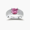Adjustable sterling silver ring with round pink moissanite center stone and pavé crystal detailing on cream background.
