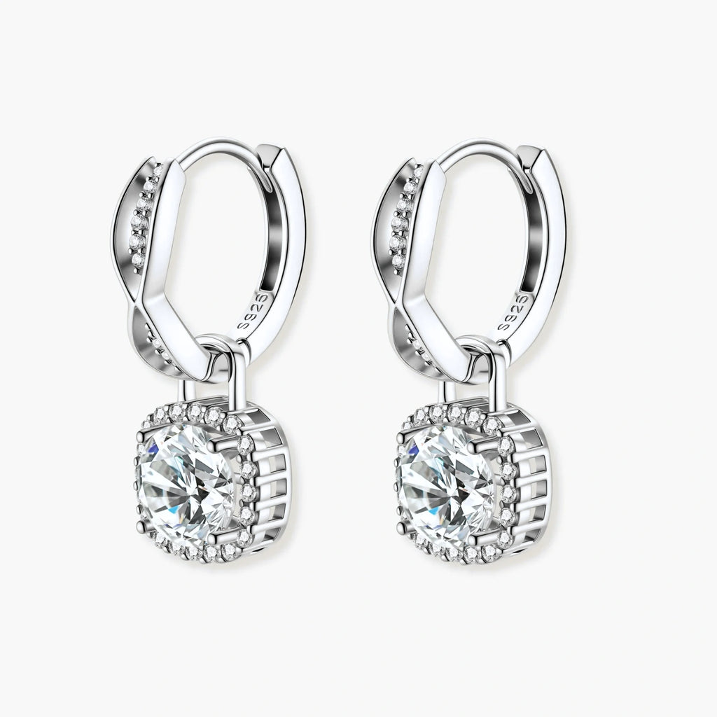 Sterling silver twisted hoop earrings with round moissanite stones in halo settings against neutral background.