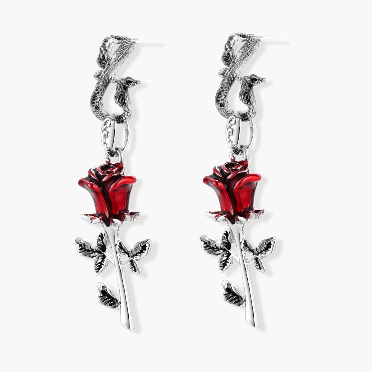 Gothic dangle earrings featuring silver serpent hooks with red enamel roses and metallic stems on white background.