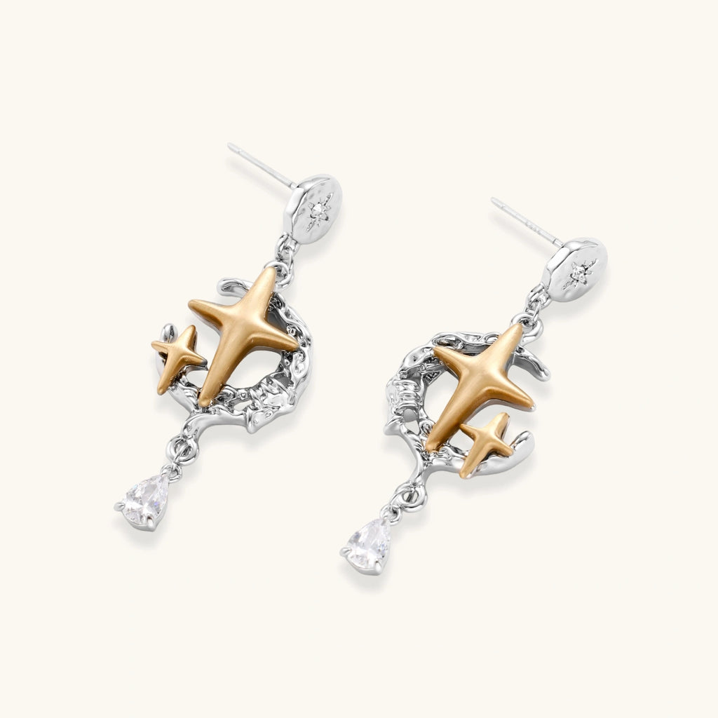 Delicate eco-brass jewelry set featuring gold star and silver moon crescents with clear zirconia crystal drops on cream background