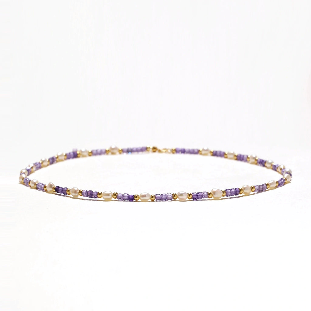 Delicate 18K gold vermeil necklace with alternating lavender zirconia beads and white freshwater pearls on cream background