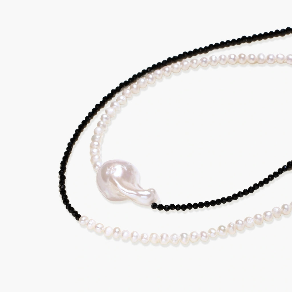 Double-strand necklace with black faceted quartz and white pearls featuring an oversized baroque pearl centerpiece