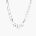 Sterling silver multi-strand necklace with three brushed round beads on cream background