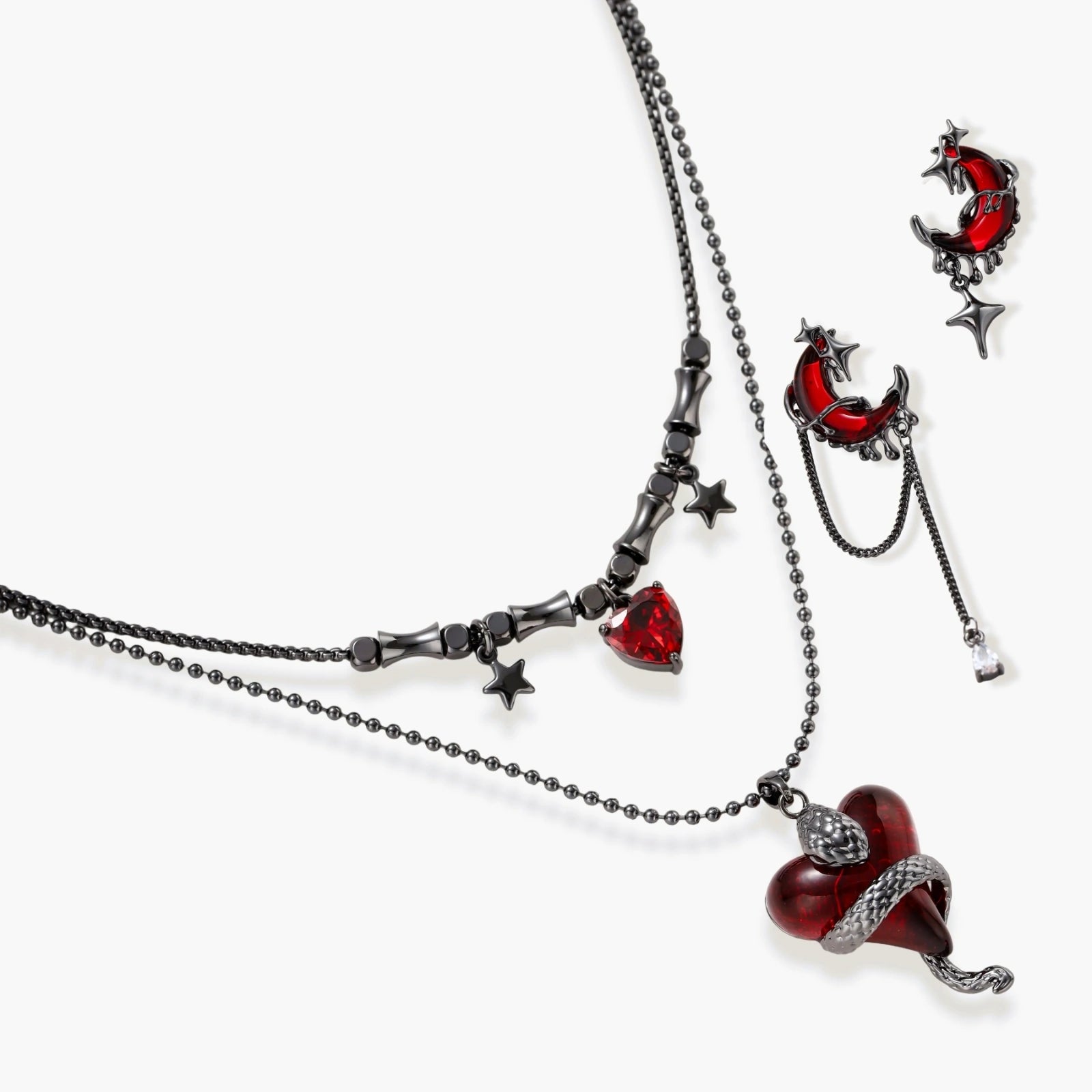Gothic jewelry set with asymmetrical black metal earrings featuring red crescent moons, stars, and layered necklaces with heart pendants