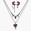 Gothic jewelry set with asymmetrical black metal earrings featuring red crescent moons, stars, and layered necklaces with heart pendants