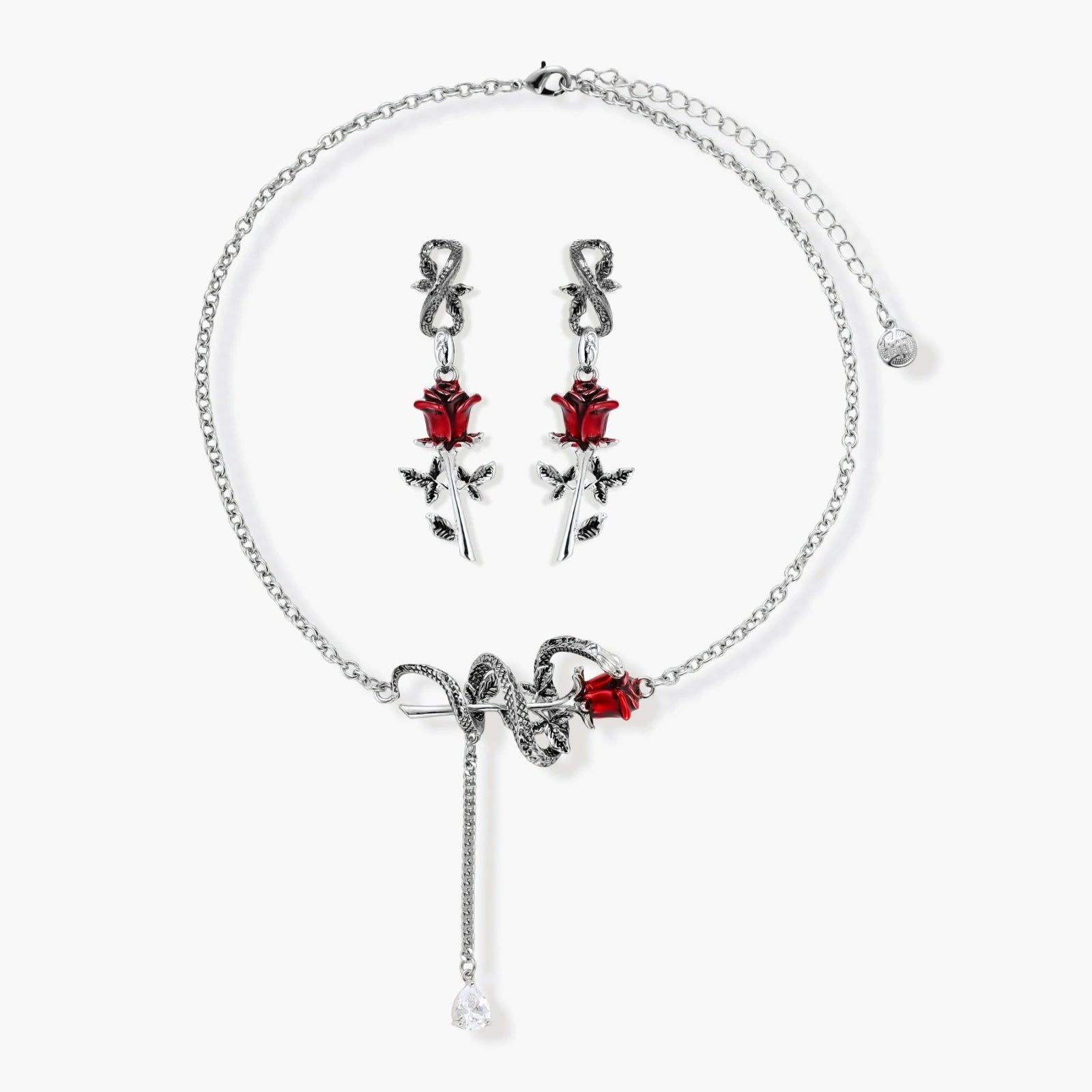 Gothic jewelry set with silver snake designs holding red enamel roses, featuring detailed leaf stems on cream background