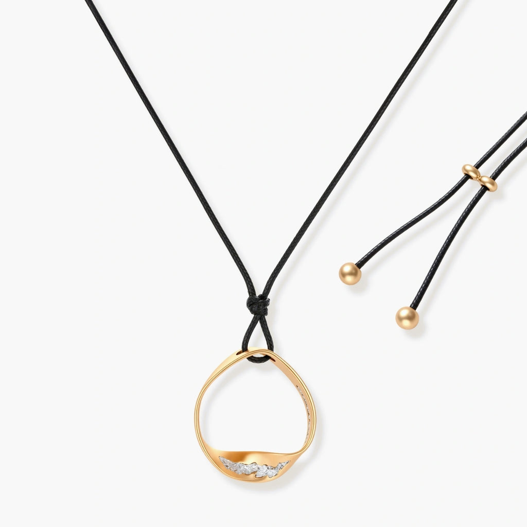 Geometric circle pendant necklace with crystal cluster on adjustable black cord, available in gold and silver finishes.