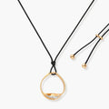 Geometric circle pendant necklace with crystal cluster on adjustable black cord, available in gold and silver finishes.