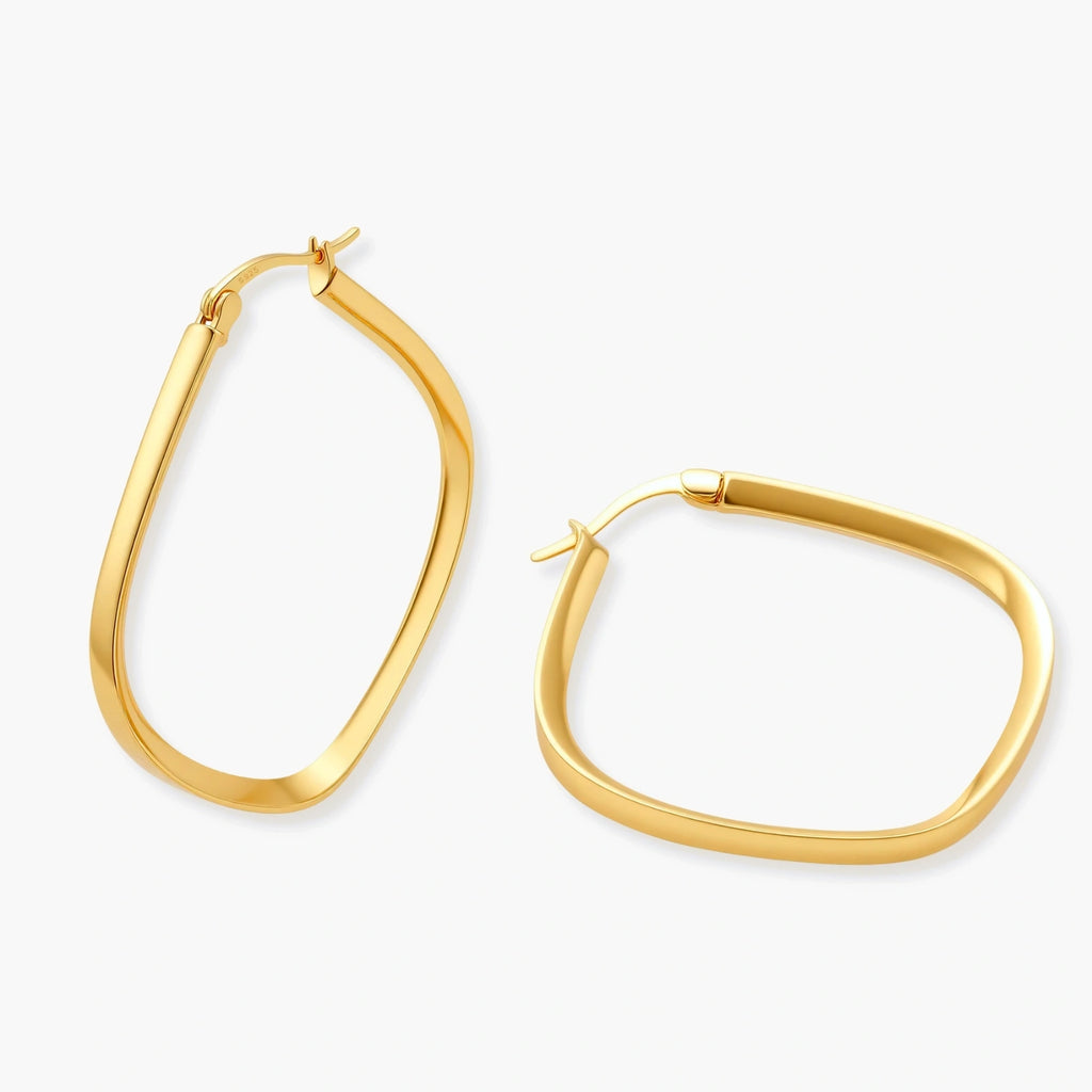 Set of geometric gold-plated sterling silver hoop earrings in oval and cushion shapes on cream background