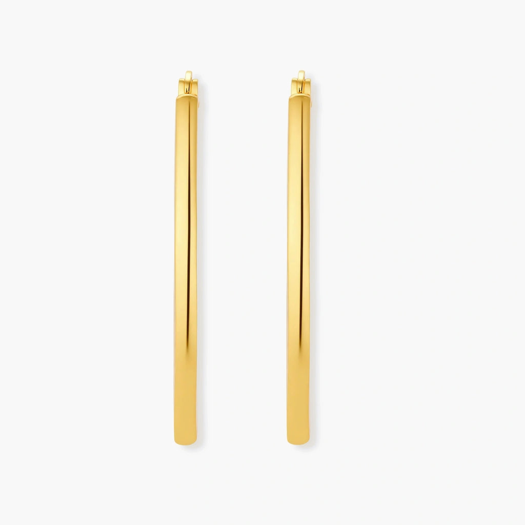Set of geometric gold-plated sterling silver hoop earrings in oval and cushion shapes on cream background