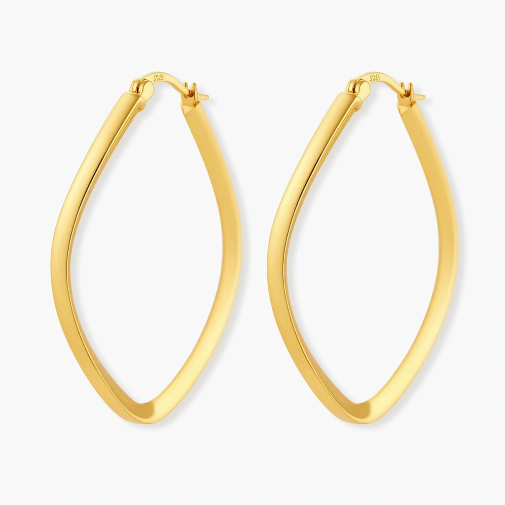 Set of geometric gold-plated sterling silver hoop earrings in oval and cushion shapes on cream background