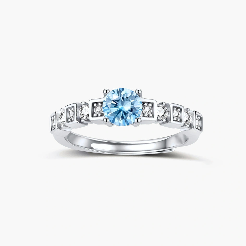 Geometric sterling silver ring with light blue moissanite center stone and square diamond accents on white background