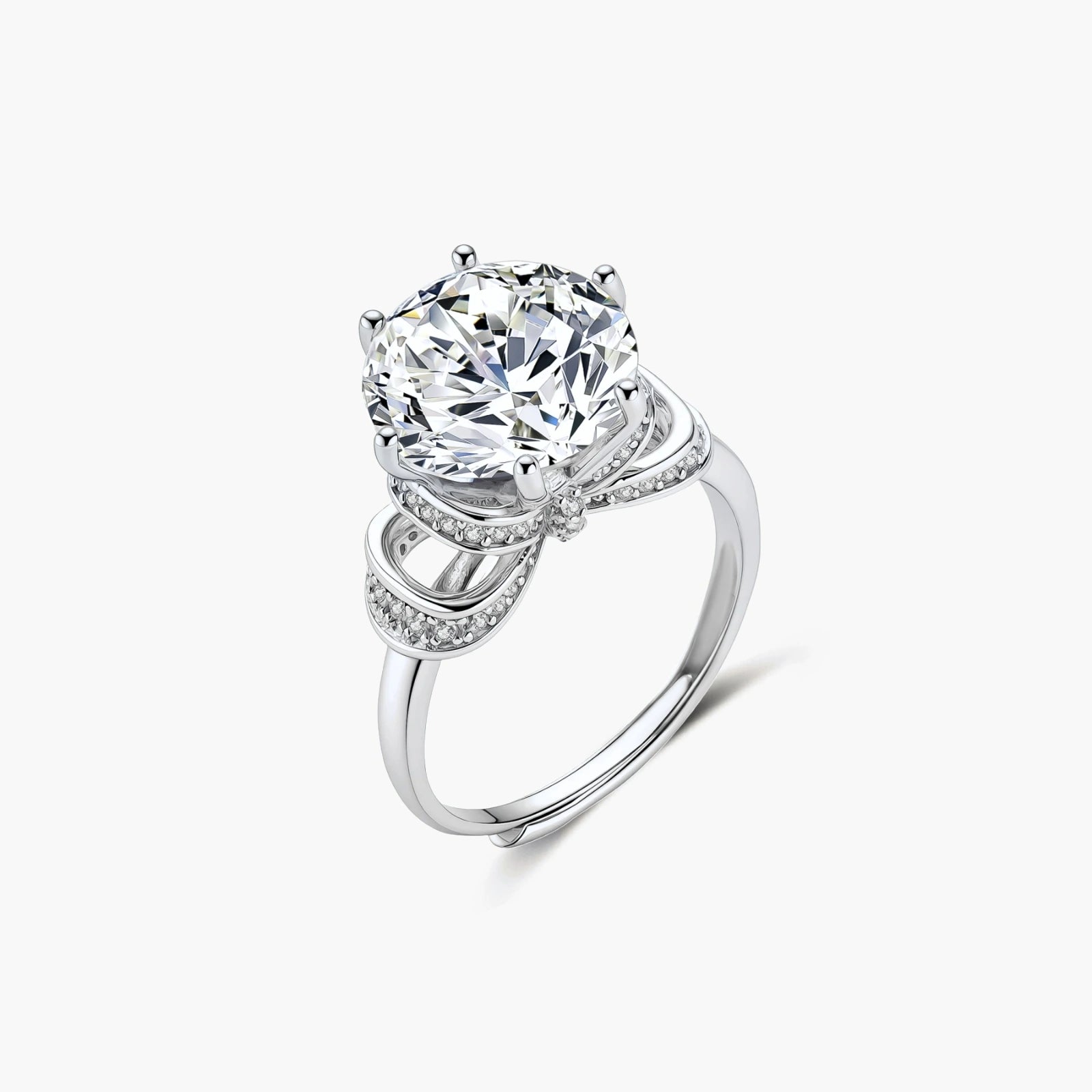 Sterling silver ring with 5ct round moissanite center stone and intricate bow design with pavé accents on white background.