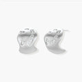Organic shaped silver stud earrings with sparkling crystal details in flowing molten design on white background.