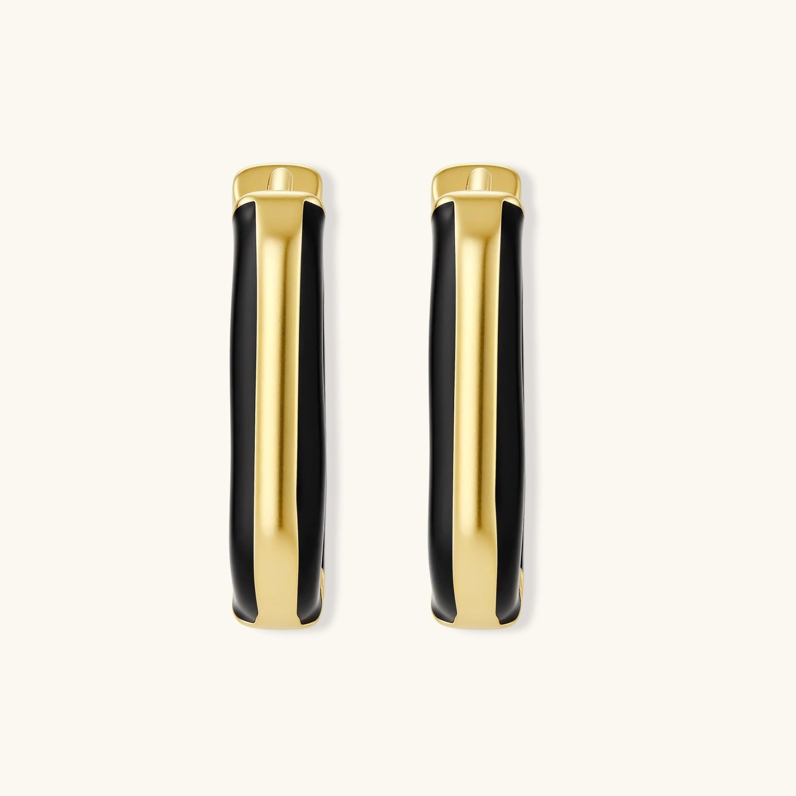 Modern hoop earrings with gold-plated and black sections, featuring hinged closure on white background.