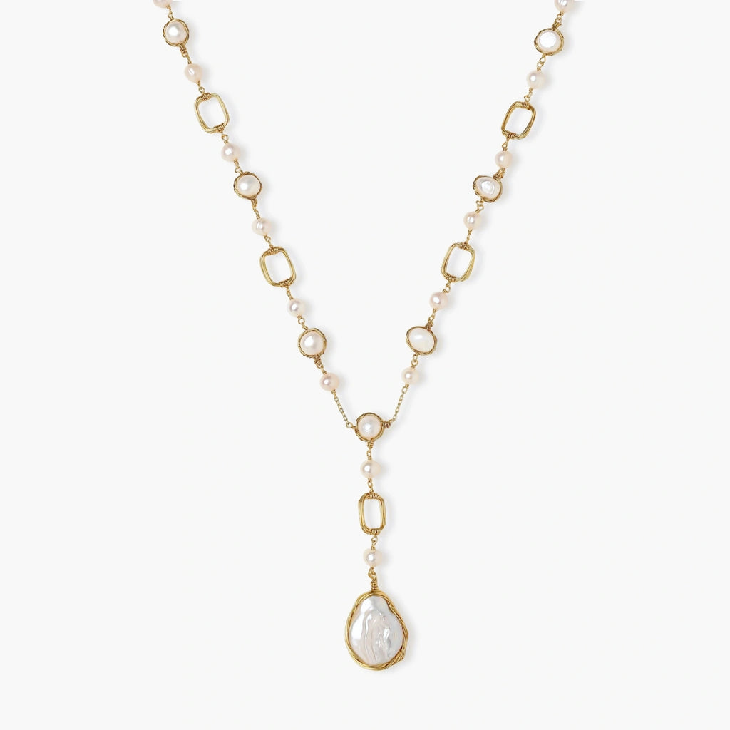 Long gold-plated necklace with alternating freshwater pearls and crystal bezels, featuring a large baroque pearl pendant