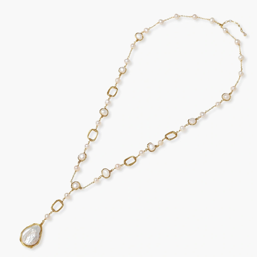 Long gold-plated necklace with alternating freshwater pearls and crystal bezels, featuring a large baroque pearl pendant